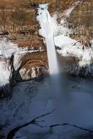 lång exponering av ett vattenfall på en stenig bergssida foto