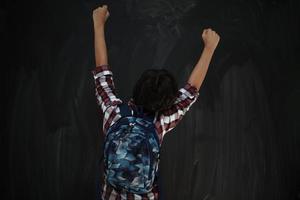 Lycklig arab tonåring fira mot svart svarta tavlan foto