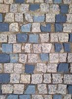 gammal väg trottoar med granit stenar. stenläggning stenar. foto