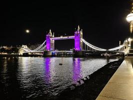 en se av torn bro i London på natt belyst upp i lila foto