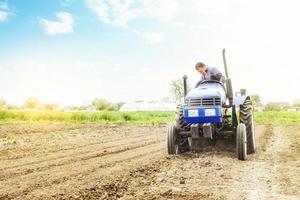 jordbrukare på en traktor med fräsning maskin lossnar, maler och blandar jord. lossna yta, odla de landa för ytterligare plantering. jordbruk och lantbruk. använda sig av av jordbruks maskineri på en odla. foto