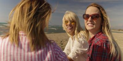 grupp av flick har roligt på strand under höst dag foto