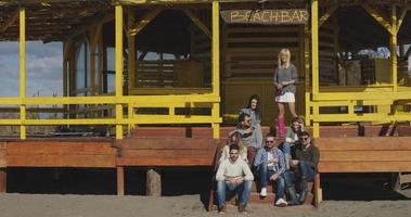 grupp av vänner har roligt på höst dag på strand foto