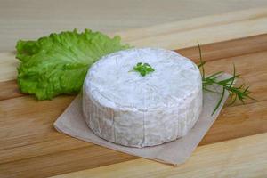 Brie ost på trä- styrelse och trä- bakgrund foto