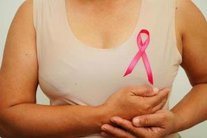 asiatisk kvinna med rosa band, värld bröst cancer dag på oktober. foto