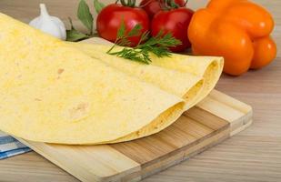 tortilla på trä- styrelse och trä- bakgrund foto