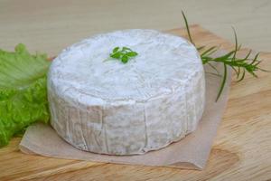Camembert ost på trä- styrelse och trä- bakgrund foto