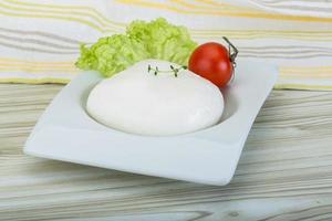 mozzarella i en skål på trä- bakgrund foto