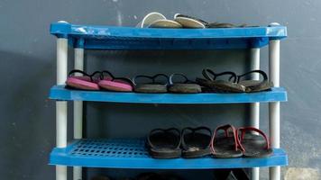 plast kuggstång för skor och sandaler i främre av de hus. blå sandal kuggstång eller sko skåp foto