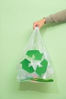 avfall återvinning, återanvändning, sopor förfogande, miljö och ekologi begrepp - stänga upp av skräp väska med skräp eller sopor och grön återvinna symbol på Hem foto