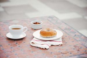 kopp av kaffe med bröd på tabell i de morgon- med solljus, frukost foto
