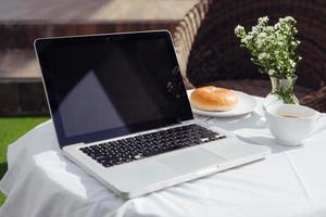 bärbar dator, bröd och Kafé i kaffe affär foto