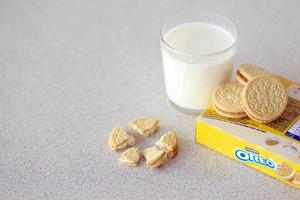 ternopil, ukraina - Maj 28, 2022 oreo gyllene Krispig småkakor med glas av mjölk på vit bakgrund. de varumärke oreo är ägd förbi företag mondelez internationell foto