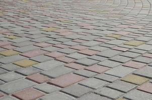 de textur av gata gränder i de form av en mosaik- tillverkad av bearbetas stenläggning stenar i solljus foto