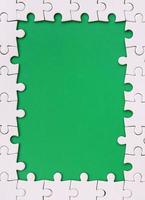 inramning i de form av en rektangel, tillverkad av en vit kontursåg pussel runt om de grön Plats foto