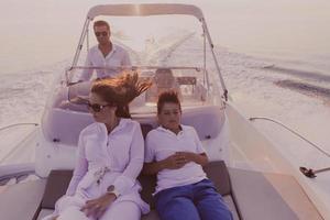 en senior par i tillfällig klädespersedlar med deras son njut av medan ridning en båt på hav på solnedgång. de begrepp av en Lycklig familj. selektiv fokus foto