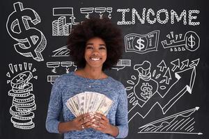 svart kvinna innehav pengar på grå bakgrund foto
