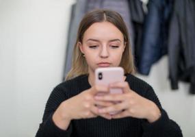 kvinna studerande använder sig av en mobil telefon foto