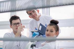 grupp av ung medicinsk studenter håller på med forskning foto