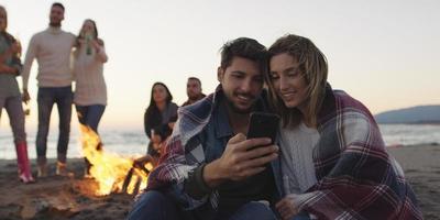 par njuter bål med vänner på strand foto