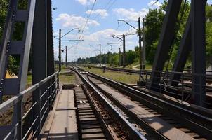 sommar dag järnväg landskap med en se från de järnväg bro till de förorts passagerare station foto