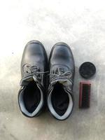 svart säkerhet skor Nästa till en sko borsta och sko putsa foto