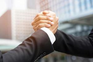 närbild av en affärsman hand skaka investerare mellan två kollegor ok, lyckas i affärer håller hand. foto