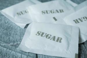 stänga upp av vit socker i en papper paket på tabell foto