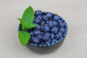 blåbär i en skål på trä- bakgrund foto