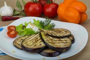 grillad aubergine på de tallrik och trä- bakgrund foto