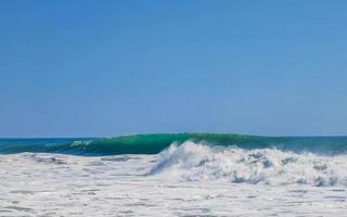 ytterst enorm stor surfare vågor på strand puerto escondido Mexiko. foto