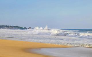 ytterst enorm stor surfare vågor på strand puerto escondido Mexiko. foto