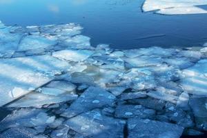 vinter- natur bakgrund med block av is på frysta vatten i vår. abstrakt bakgrund av drivande is på vatten foto