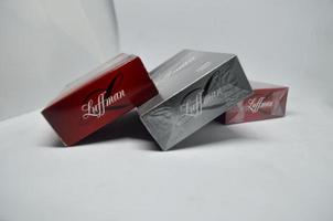 blitar, indonesien - september 30:e 2022 tre förpackningar av luffman varumärke cigaretter i två Färg varianter, röd och svart isolerat på en vit bakgrund foto