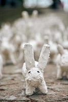 vita kaninstatyer gjorda av gips närbild, konstutställning utomhus, konstgjorda vita harar foto