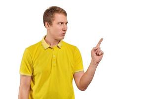 irriterad ung man i gul t-shirt hotfull vara Mer uppmärksam, vit bakgrund, finger gest foto