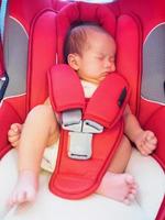 nyfödd bebis sitta i de bil sittplats för säkerhet foto