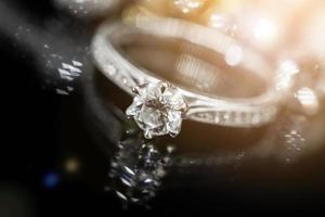 Smycken diamant ringar med reflexion på svart bakgrund foto