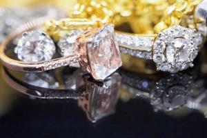 lyx guld Smycken diamant och rosa topas ringar med reflexion på svart bakgrund foto