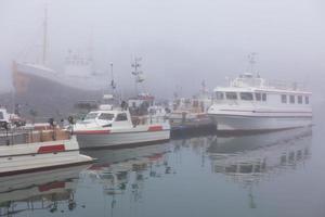 fiske fartyg i en dimmig dimmig morgon- i hofn, island foto