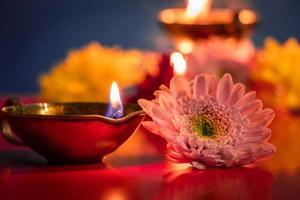 Lycklig diwali. brinnande diya olja lampor och blommor på blå bakgrund. traditionell indisk festival av ljus. foto