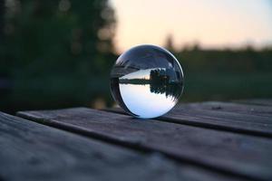 glas boll på en trä- pir på en svenska sjö på kväll timme. natur skandinavien foto