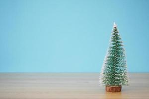 jul träd på trä tabell med blå vägg bakgrund foto