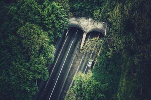 Drönare skott av motorväg tunnel i rotterdam omgiven förbi träd och skog foto