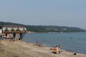 sukhumi, abkhazia - augusti 5, 2017 marinmålning med människor på de strand av sanatorium av moskva militär distrikt foto