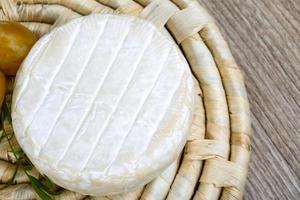 Brie ost på trä- styrelse och trä- bakgrund foto