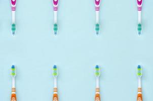 en massa av tandborstar lögn på en pastell blå bakgrund. topp se, platt lägga. minimal begrepp foto
