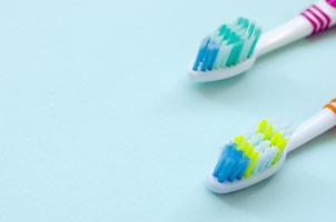 två tandborstar lögn på en pastell blå bakgrund. topp se, platt lägga. minimal begrepp foto