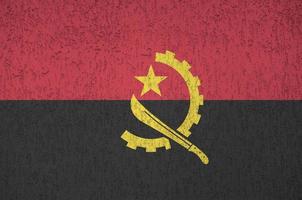 angola flagga avbildad i ljus måla färger på gammal lättnad putsning vägg. texturerad baner på grov bakgrund foto