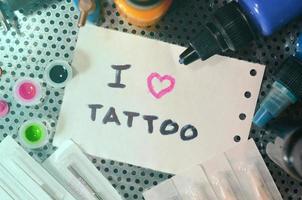 jag kärlek tatuering. de text är skriven på en små ark av papper bland olika Utrustning för tatuering foto
